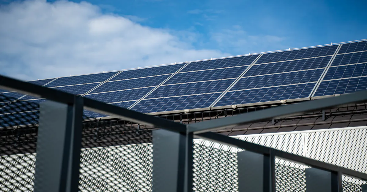 Close-up view of modern solar panels on a rooftop against a clear blue sky, representing clean energy.